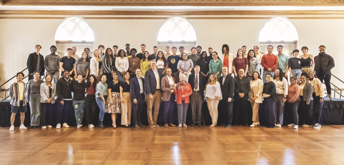 Davis UWC Scholars at the University of Oklahoma pose together on risers in a gymnasium.